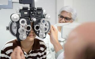 Boy has his eyes checked for glasses by a specialist. photo