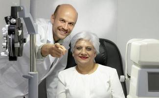 Ophthalmologist measures eyesight for an elderly woman. photo