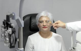 Ophthalmologist measures eyesight for an elderly woman. photo