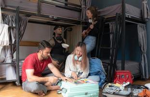 Groups of travelers of different nationalities having fun in the hostel. photo