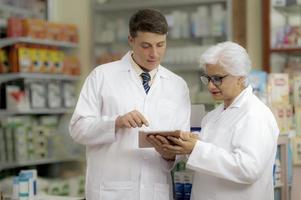 Young caucasian pharmacist and Indian female pharmacist. photo