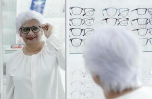 Elderly woman trying on new glasses. photo