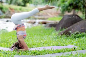 Young woman yoga outdoors on the lawn. photo