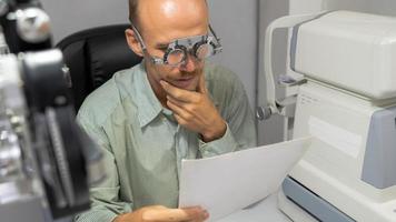 Young man checking his eyes to make glasses. photo