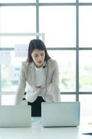 Young asian woman working at a call center Consulting about stock investment information with customers calling for advice with emotion of serious photo