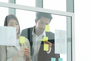 Young entrepreneurs in Asia Organize meetings to brainstorm and review information on glass board photo