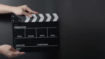 Movie slate or clapperboard hitting. Close up hand holding video