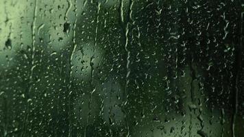 Rain drops on the glass. Small raindrop rests on glass while raining. video