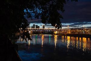 vista nocturna del río y el puente sobre él. foto