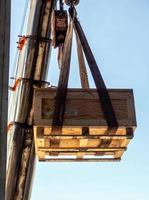 la grúa levantando el portainstrumentos radiactivos transporte caja de madera foto