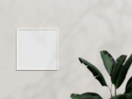 Clean and minimalist front view square white photo or poster frame mockup hanging on the wall with plant. 3d rendering.