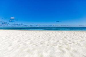 Closeup sand beach sea waves and blue summer sky. Panoramic beach landscape. Empty tropical beach and seascape, horizon. Bright exotic coast calmness, tranquil seaside nature view relaxing sunlight photo