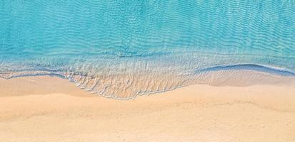 Relaxing aerial beach scene, summer vacation holiday template banner. Waves surf with amazing blue ocean lagoon, sea shore, coastline. Perfect aerial drone top view. Peaceful bright beach, seaside photo