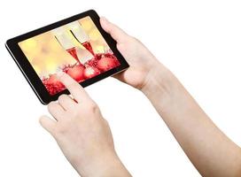 La mano hace clic en tablet pc con bodegón de Navidad foto