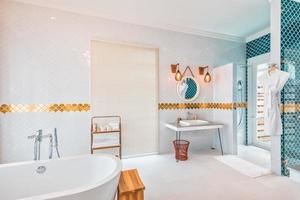 baño grande y moderno. cuarto de baño de mármol de oro blanco de lujo con bañera independiente de lujo y lavabos. concepto de estilo de vida y vida de lujo. foto