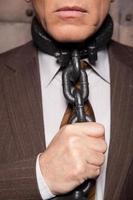 Chains on his neck. Cropped image of senior man in formalwear trying to take off the chain from his neck photo