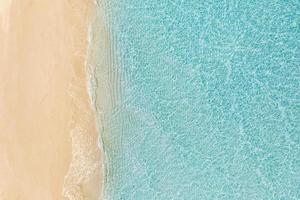 Relaxing aerial beach, summer vacation holiday template banner. Waves surf with amazing blue ocean lagoon, sea shore, coastline. Beautiful aerial drone top view. Tranquil bright beach, seaside nature photo