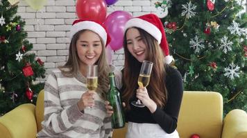 Asian women happily drinking champagne and Christmas video