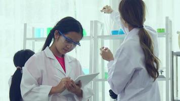 asiatico studentesse siamo studiando scienza e tecnologia nel un' laboratorio. insegnanti insegnare scienza per studenti per apprendimento processi abilità. video