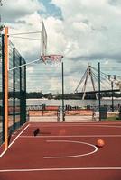 esperando jugadores. Una foto de una pelota de baloncesto tirada en el patio de juegos de baloncesto vacío al aire libre