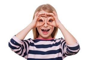 Time to fun. Cheerful little girl having fun while standing isolated on white photo