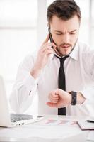 momentos de trabajo. apuesto joven barbudo con camisa y corbata trabajando en su lugar de trabajo foto