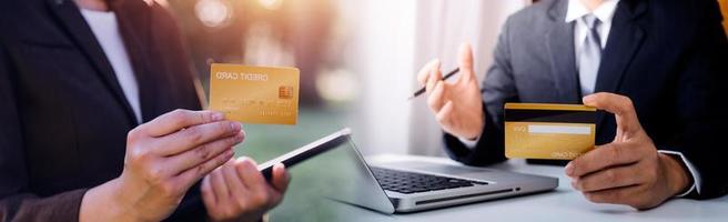 manos de mujer sosteniendo y usando tarjeta de crédito para comprar en línea. foto