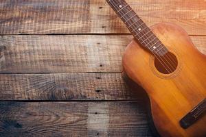 Wooden guitar. Close-up of guitar lying on vintage wood background photo