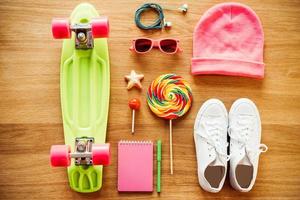 Girls collection. Top view of clothing and diverse personal accessory for teenage girls laying on the wooden grain photo