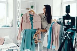 hermosa joven con ropa informal haciendo videos en las redes sociales mientras pasa tiempo en casa foto