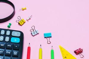 Various office supplies on a pink background. Back to school concept. photo