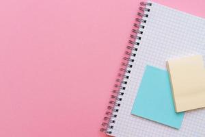 School spiral notebook on a pink background stickers lie on top of the sheet. photo