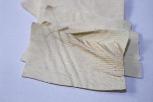 A pile of used patches that are bent and there are traces of hair pulled out and attached to the patch. photo