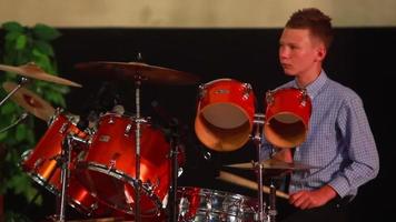 boy playing drum set in the room on the stage video