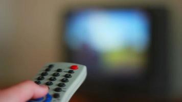 mano Tenere tv a distanza controllo con un' televisione nel il sfondo video