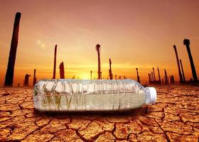 concept of water scarcity Drought due to global warming. Water bottles placed in drought and broken soil areas photo