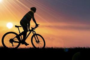 siluetas de bicicletas de montaña y ciclistas por la noche felizmente. concepto de viaje y fitness. silueta de ciclistas recorriendo el concepto de cicloturismo vespertino foto