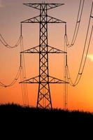 Silhouettes of high voltage poles and power lines It has a complex steel structure, it is strong and durable. photo