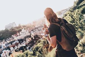 Young and free. Rear view of young man in casual clothing looking at view while standing on the hill outdoors photo