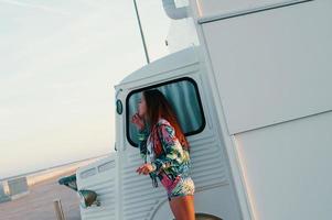 Everything should be perfect. Attractive young woman looking in the mirror while standing against food truck outdoors photo