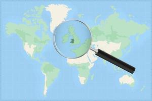 Map of the world with a magnifying glass on a map of Wales. vector