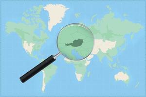 Map of the world with a magnifying glass on a map of Austria. vector