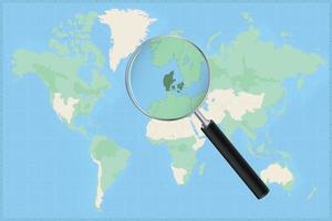 Map of the world with a magnifying glass on a map of Denmark. vector