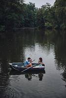 Capturing the beauty. Top view of young man photographing his beautiful girlfriend while enjoying romantic date on the lake photo