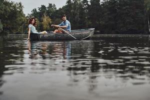 simplemente relajarse. hermosa pareja joven disfrutando de una cita romántica mientras rema en un bote