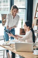 What do you think about this Beautiful young women looking and touching clothing while spending time in the workshop photo