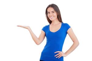 Holding a copy space. Beautiful young smiling woman holding a copy space and smiling while standing isolated on white photo