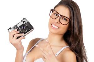 Beauty with camera. Attractive young woman in lingerie holding camera and gesturing photo