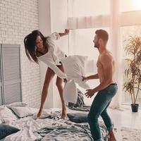 No losers in love. Happy young couple having a fun pillow fight while spending carefree time in the bedroom photo