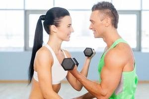 Fit couple. Fitness couple in the gym exercising in gym and looking at each other photo